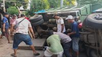 Polisi RW Bersama Warga Bantu Evakuasi Truk yang Terperosok di Selokan